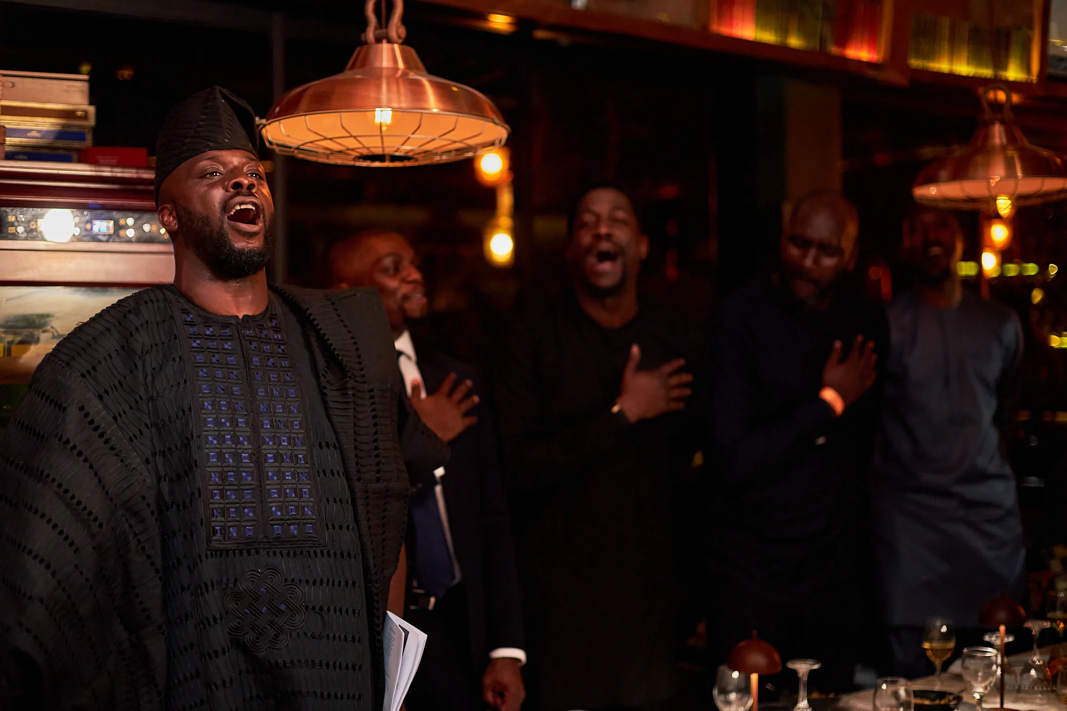 Members of The Hill Club singing the national anthem